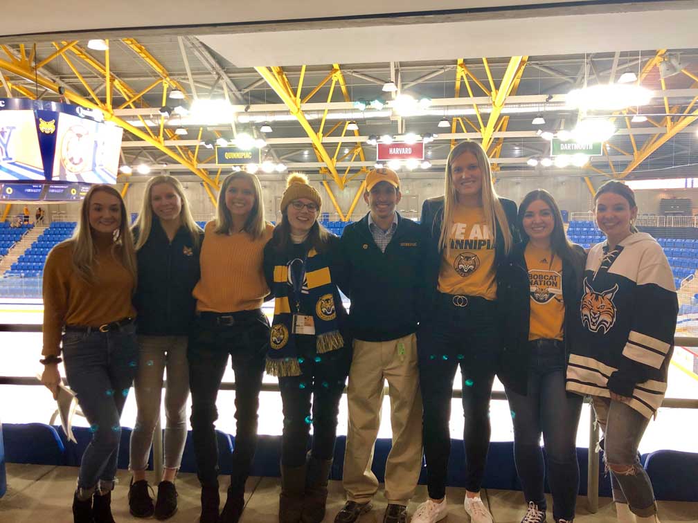 group of people in a line posing for a photo at an ice rink
